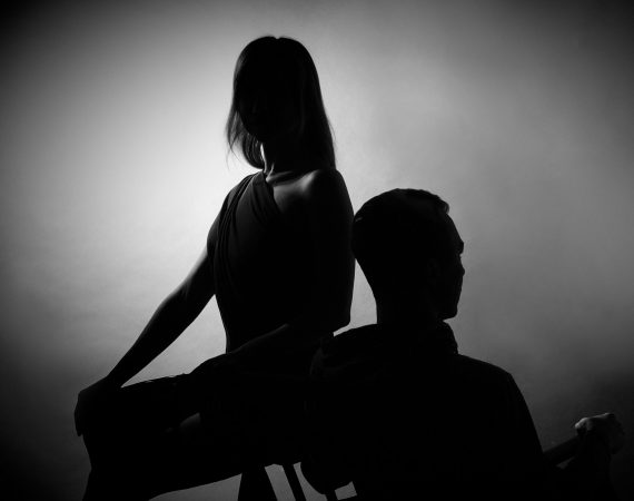 Silueta de una mujer y un hombre en una postura de disputa, simbolizando conflictos legales y disputas judiciales.